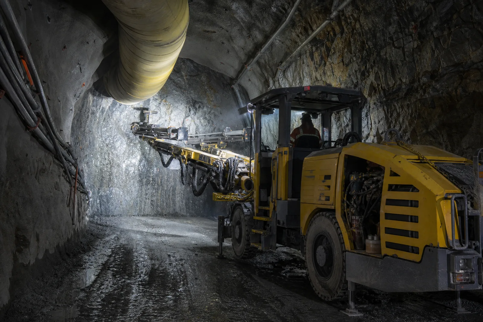 A jumbo drill rig working at an underground mine development face